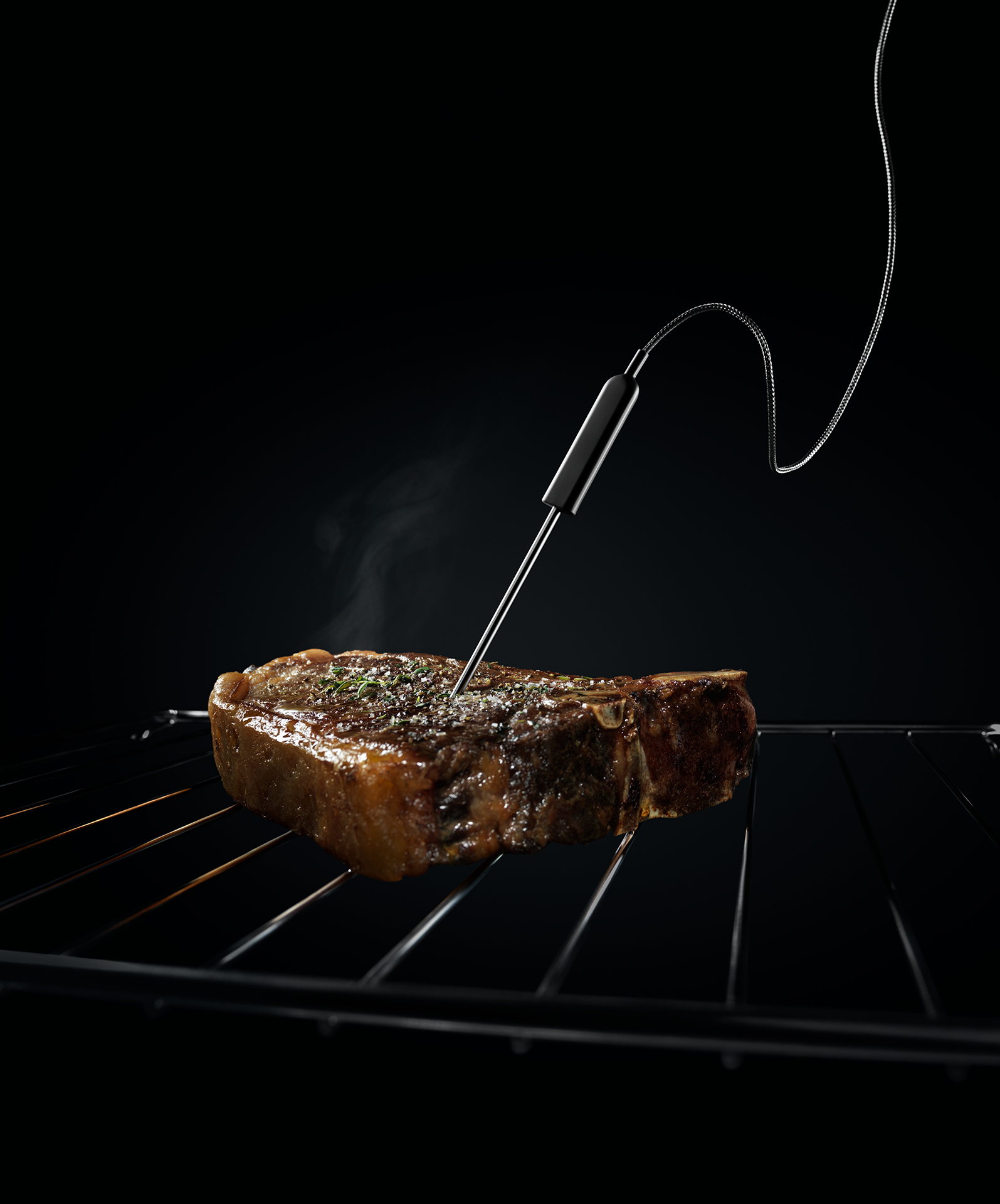 Steak mit Gargutsensor auf einem Rost.