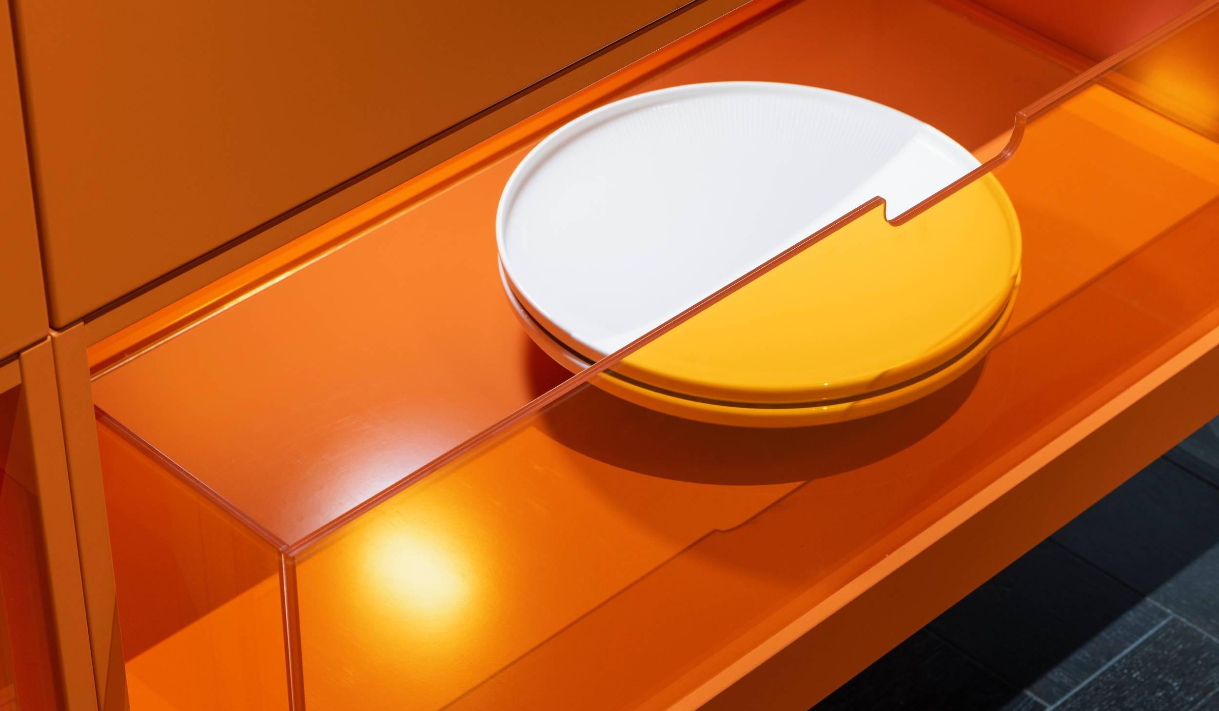 HÄCKER Systemat Betonküche mit Statement-Sideboard in orange - Detailansicht mit orangem Plexiglas als Schublade